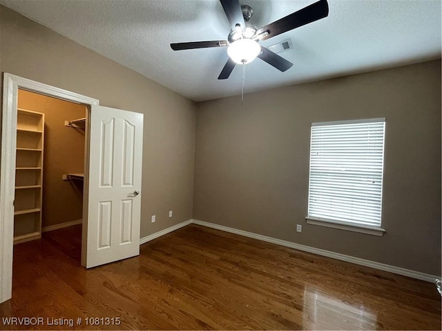 1801 Fianna Way, Fort Smith, AR 72908 - unfurnished bedroom with a spacious closet, wood finished floors, baseboards, a closet, and a textured ceiling