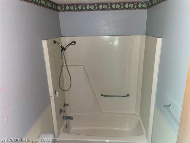 bathroom with toilet and tub / shower combination