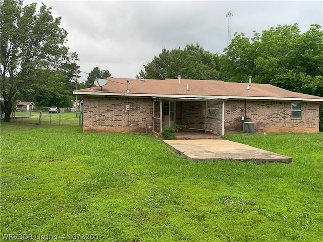 rear view of house with a lawn, a patio, and central AC