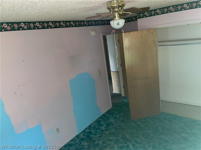 unfurnished bedroom with ceiling fan, a closet, dark carpet, and a textured ceiling