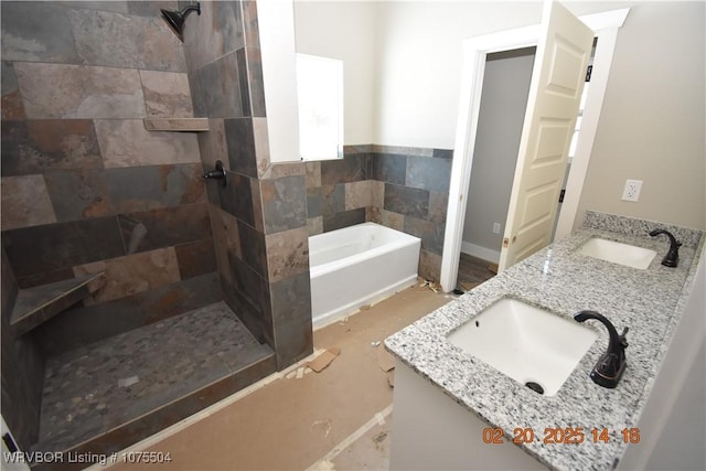 bathroom featuring double vanity, a sink, a tile shower, and a bath