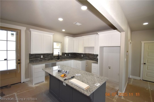 kitchen featuring a center island, white cabinetry, recessed lighting, light stone countertops, and french doors