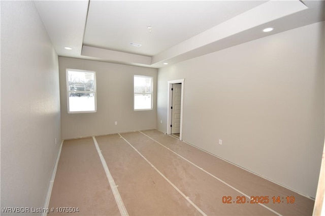 spare room with a raised ceiling and recessed lighting