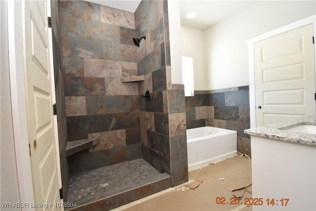 bathroom with tile walls, a tile shower, vanity, and a bath