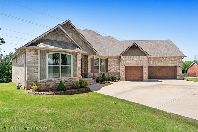 craftsman-style house with roof with shingles, concrete driveway, an attached garage, a front yard, and brick siding