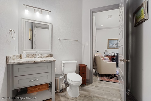 full bathroom with visible vents, toilet, wood finished floors, and vanity