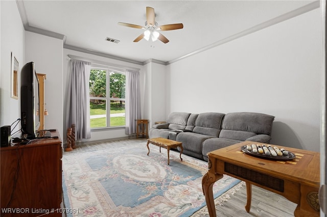 living room featuring ceiling fan, visible vents, wood finished floors, and ornamental molding