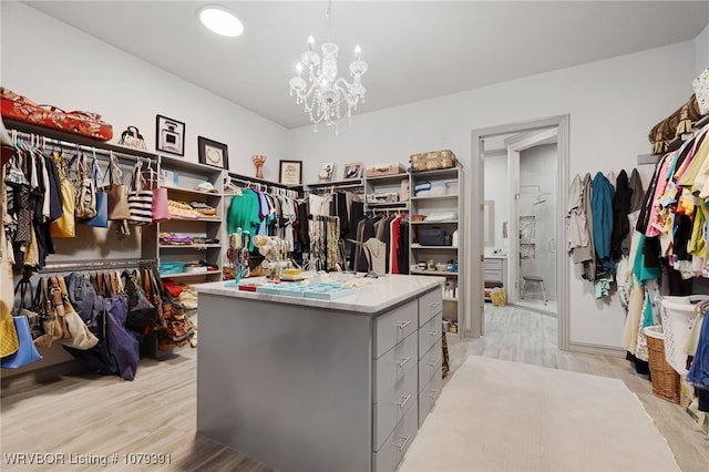 spacious closet featuring light wood-style floors and a chandelier