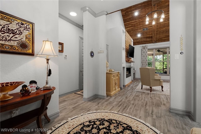 interior space with visible vents, wood ceiling, a fireplace, and light wood-type flooring