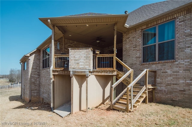 back of house with stairway, brick siding, and ceiling fan