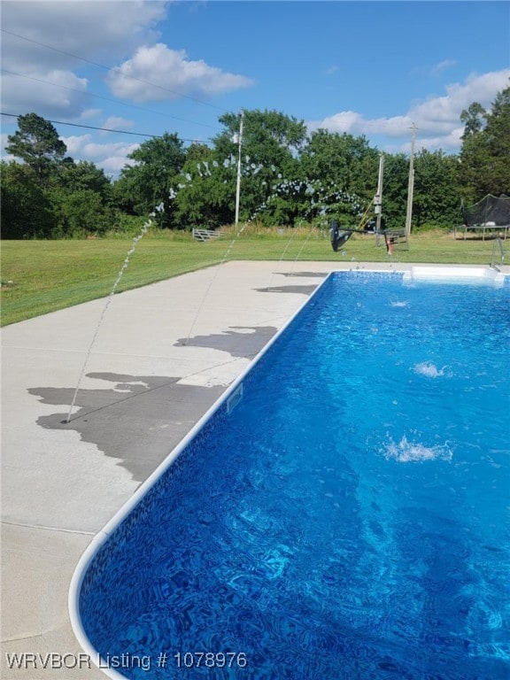 pool featuring a yard and a trampoline