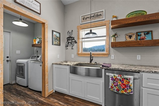 kitchen featuring dishwasher, washing machine and clothes dryer, dark wood-style flooring, and a sink