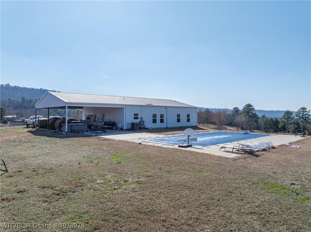 view of swimming pool featuring a covered pool, cooling unit, a mountain view, and a patio area