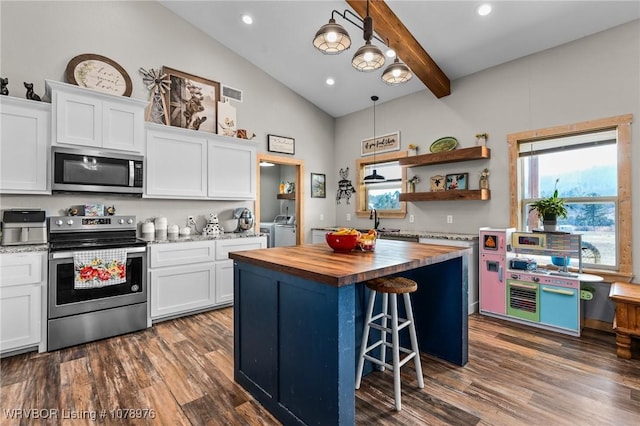 kitchen featuring white cabinets, washing machine and dryer, appliances with stainless steel finishes, and butcher block counters