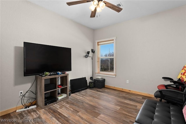 living area featuring ceiling fan, visible vents, baseboards, and wood finished floors