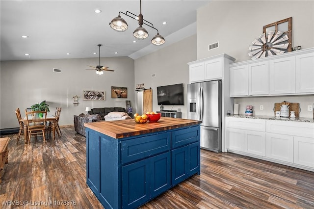 kitchen with visible vents, blue cabinetry, white cabinets, wood counters, and stainless steel fridge