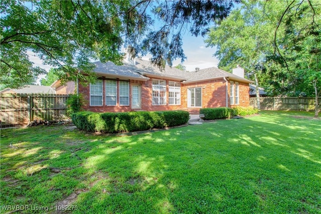 2112 Rannoch Trce, Fort Smith, AR 72908 - back of property featuring a chimney, brick siding, and a fenced backyard