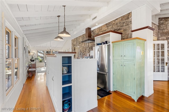 kitchen featuring pendant lighting, vaulted ceiling with beams, stainless steel fridge, wooden ceiling, and light hardwood / wood-style flooring