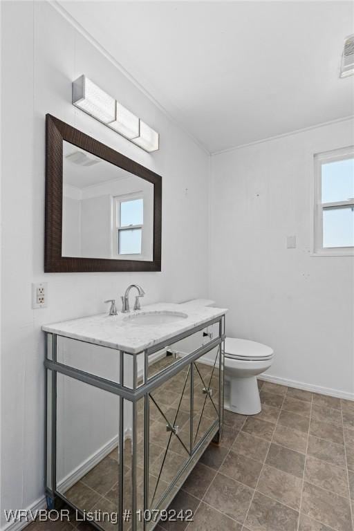 bathroom with baseboards, vanity, and toilet