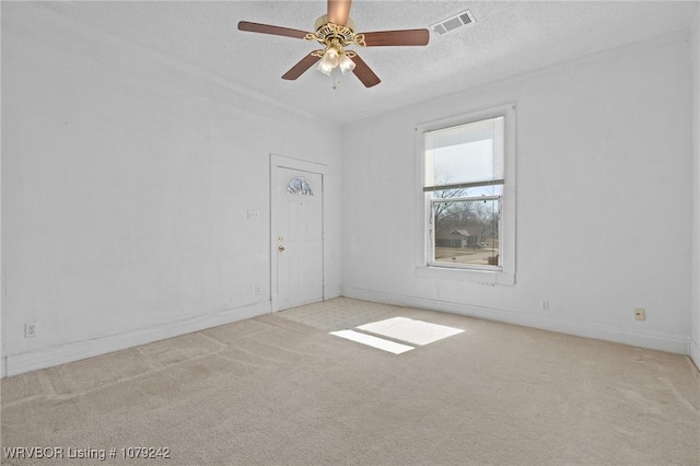 unfurnished room featuring carpet, visible vents, ceiling fan, a textured ceiling, and baseboards