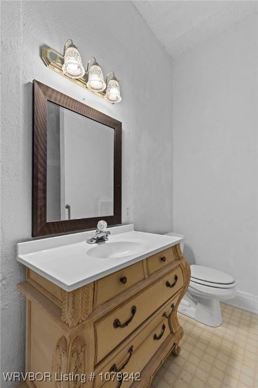 bathroom with vanity, toilet, and tile patterned floors