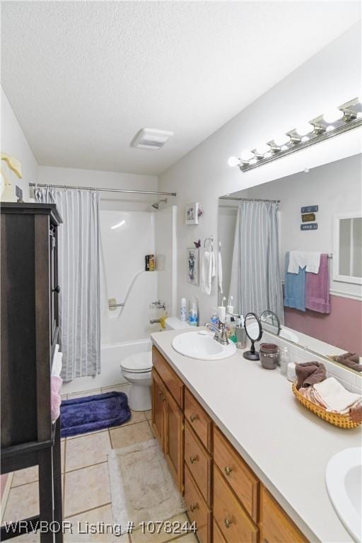 full bathroom featuring tile patterned flooring, a textured ceiling, toilet, shower / bath combo with shower curtain, and vanity