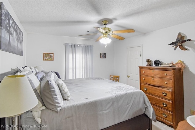 bedroom with ceiling fan and a textured ceiling