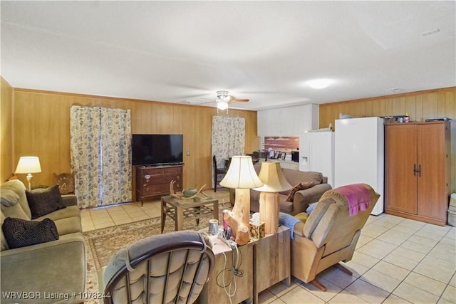 tiled living room with ceiling fan and wood walls