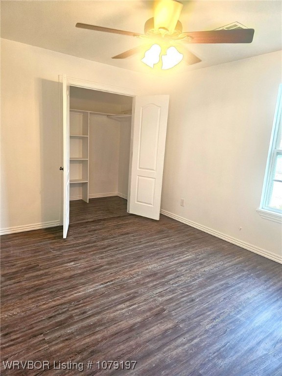 unfurnished bedroom with baseboards and dark wood finished floors