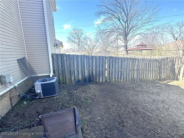 view of yard featuring central AC and fence