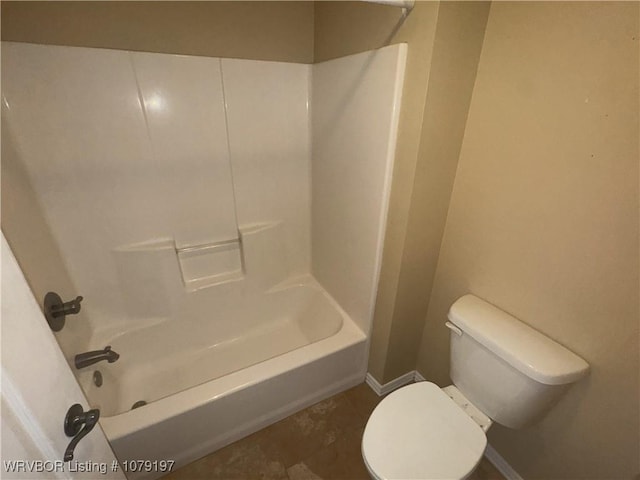 full bathroom with baseboards, washtub / shower combination, and toilet