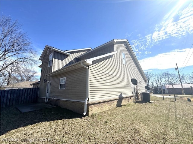 view of home's exterior featuring fence and central AC