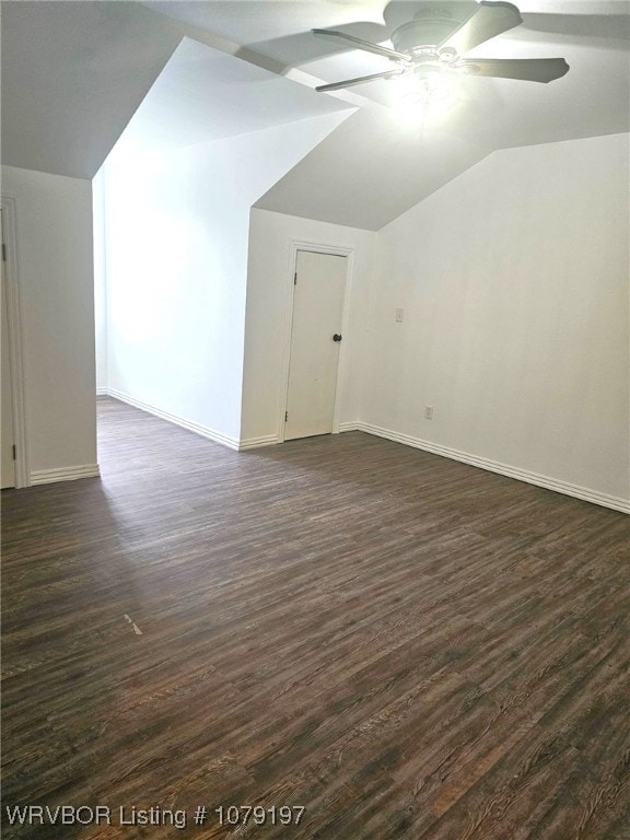additional living space with dark wood-style flooring, ceiling fan, baseboards, and lofted ceiling