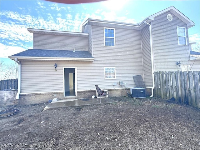 rear view of property featuring a patio area, central AC, and fence