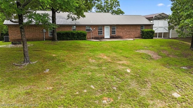 42735 Timber Ridge Rd, Howe, OK 74940 - rear view of property featuring brick siding, cooling unit, metal roof, and a lawn