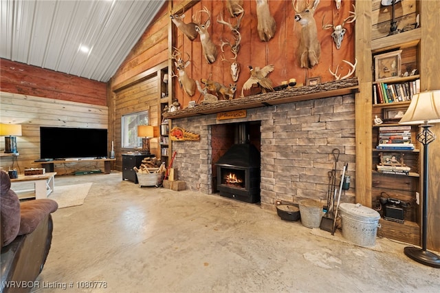 465 Boyd Dr, New Blaine, AR 72851 - living area featuring wood walls, unfinished concrete floors, lofted ceiling, and a wood stove