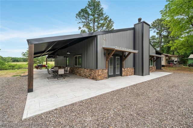 465 Boyd Dr, New Blaine, AR 72851 - back of property with stone siding, a patio area, french doors, a chimney, and a ceiling fan