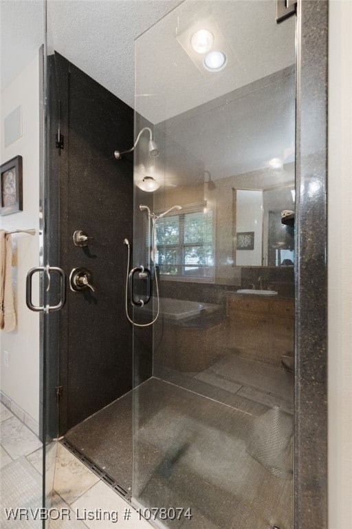 bathroom featuring a shower with shower door and a textured ceiling