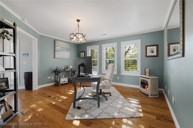 office with light hardwood / wood-style floors, crown molding, and a notable chandelier