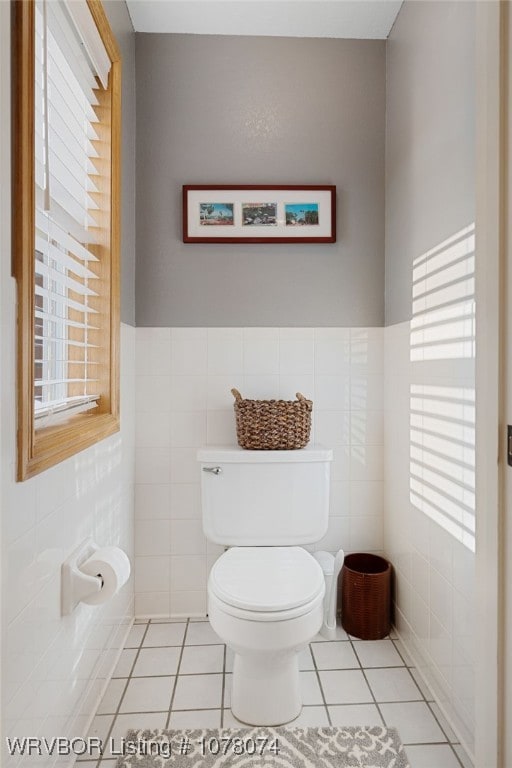 bathroom with tile patterned floors, tile walls, and toilet