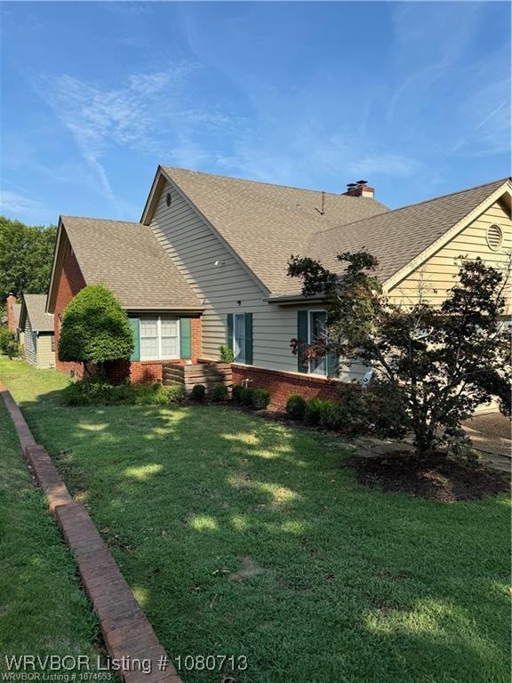 2925 Gary St Unit 12, Fort Smith, AR 72901 - rear view of house featuring roof with shingles, a chimney, a yard, and brick siding