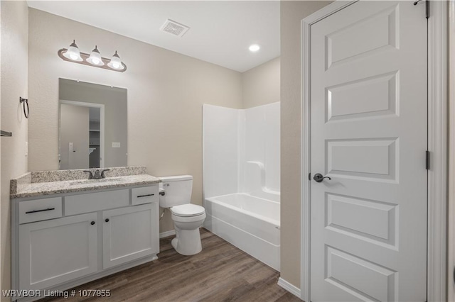 full bathroom featuring hardwood / wood-style floors, vanity, toilet, and bathing tub / shower combination