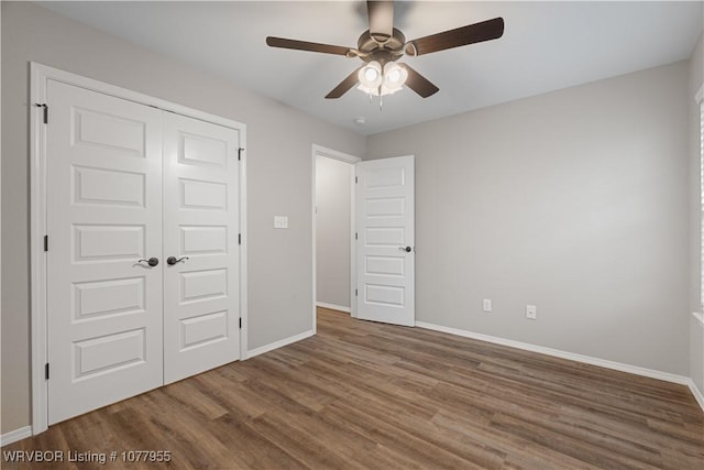 unfurnished bedroom with dark hardwood / wood-style flooring, ceiling fan, and a closet