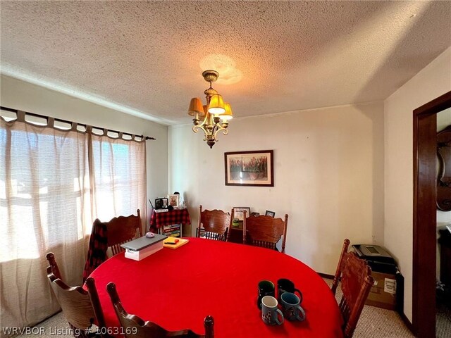 dining area featuring carpet, a textured ceiling, and an inviting chandelier