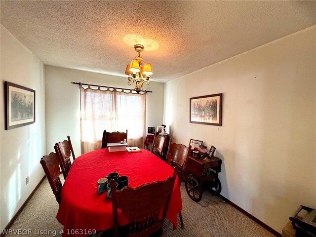 dining area with carpet flooring, a chandelier, and a textured ceiling