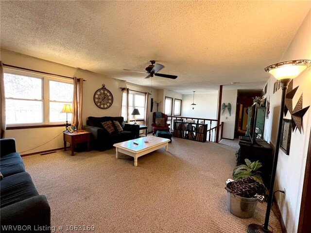 carpeted living room featuring a textured ceiling and ceiling fan