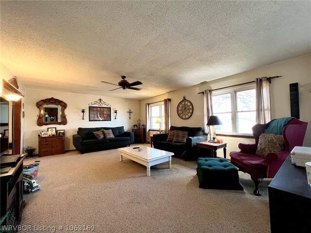 carpeted living room with ceiling fan and a textured ceiling