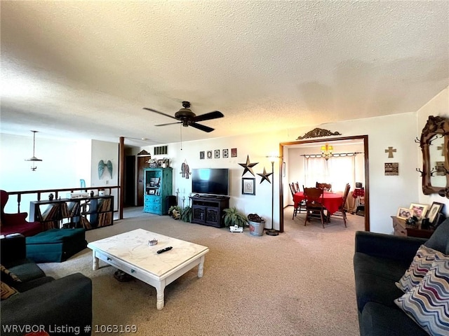 carpeted living room featuring ceiling fan and a textured ceiling