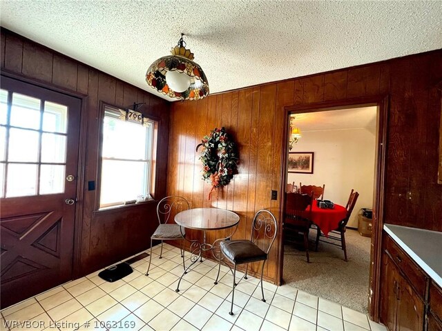 dining room with wooden walls and a textured ceiling