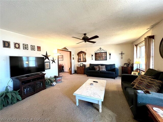 carpeted living room with ceiling fan and a textured ceiling